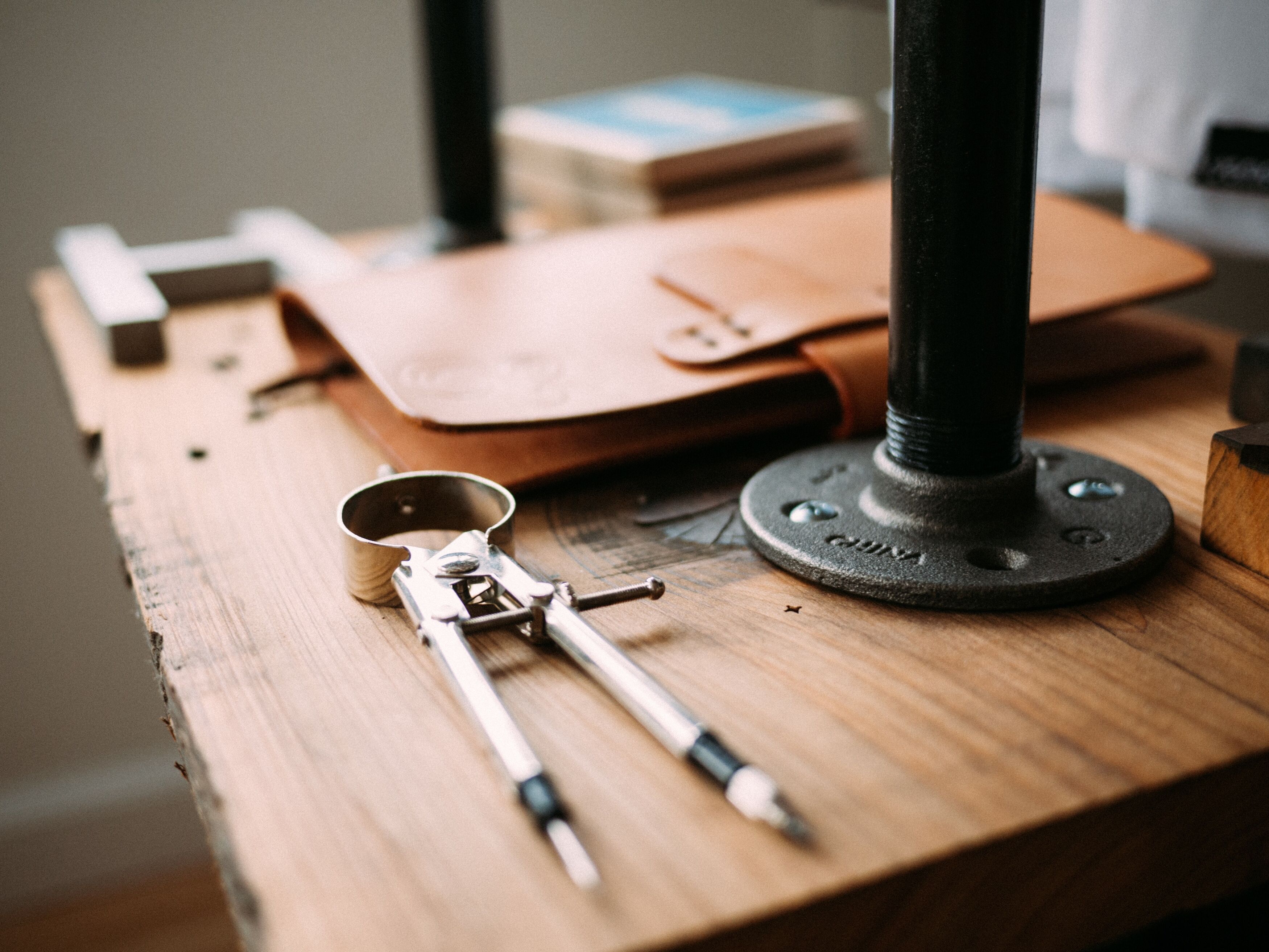 Compass and leather folder on a wooden desk
