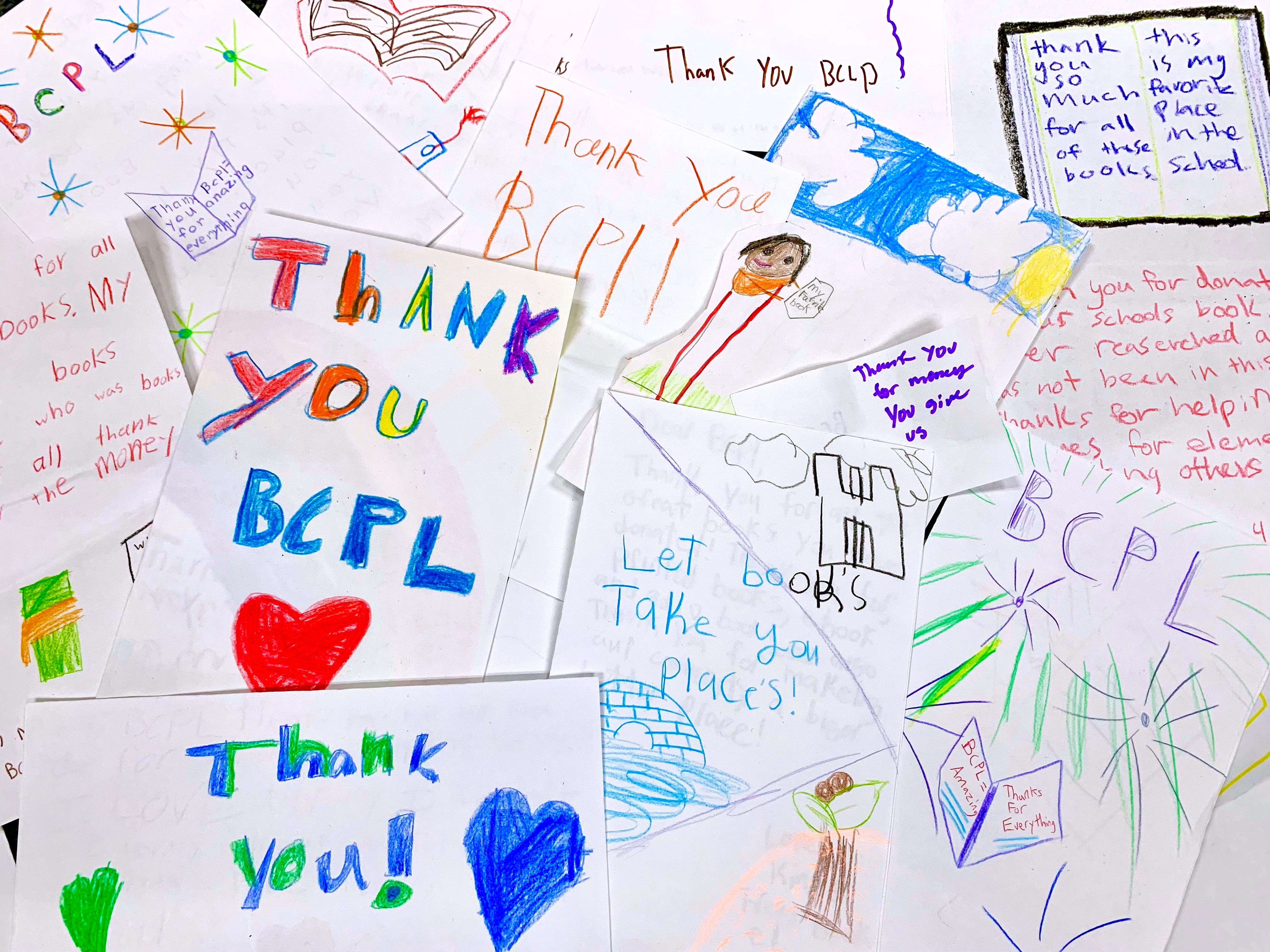 2021-2023 Biennial report cover with hand drawn notes from school children that benefit from library aid distrbutons