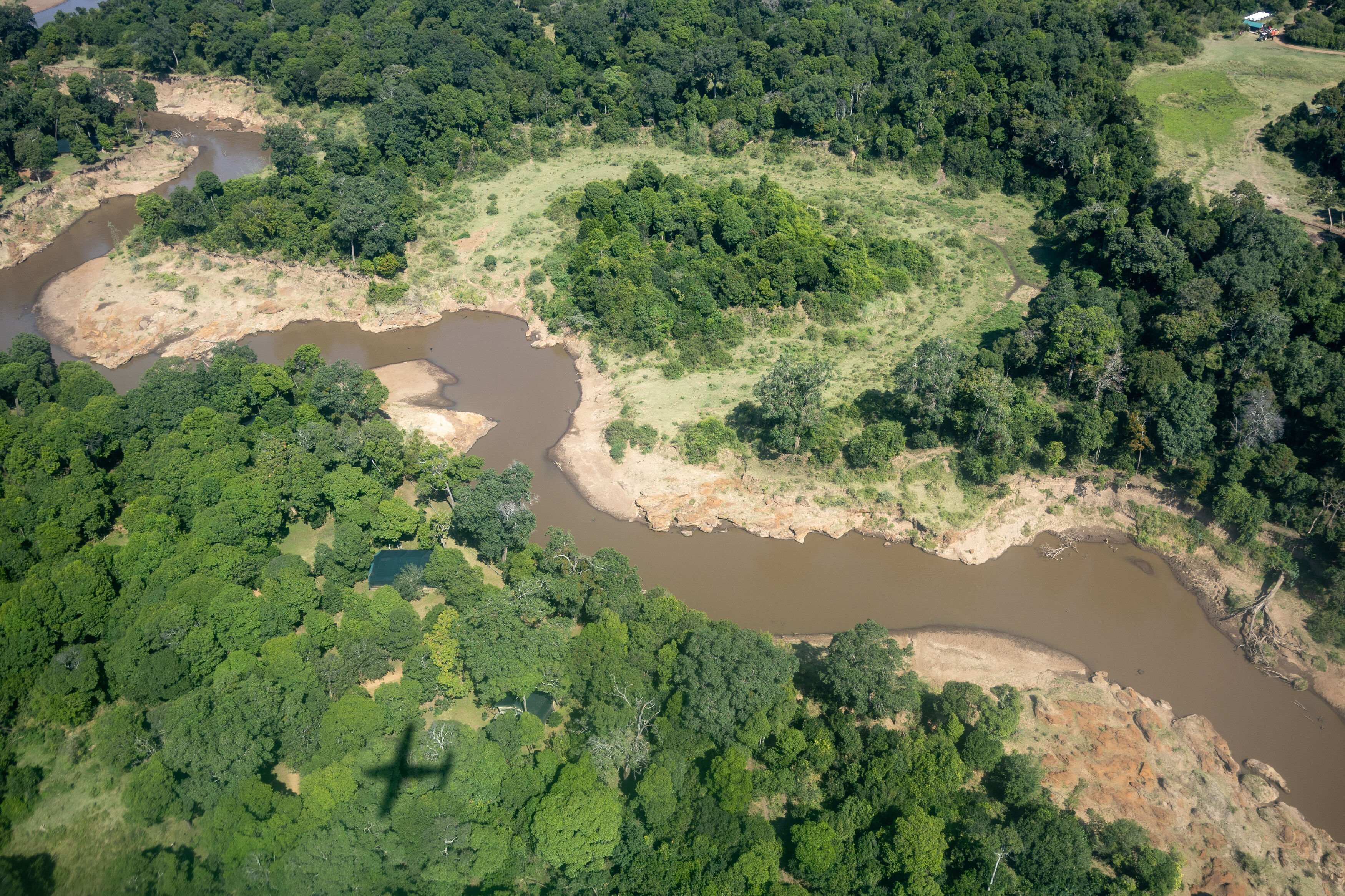 Aerial view of river winding through a forest with several oxbows.