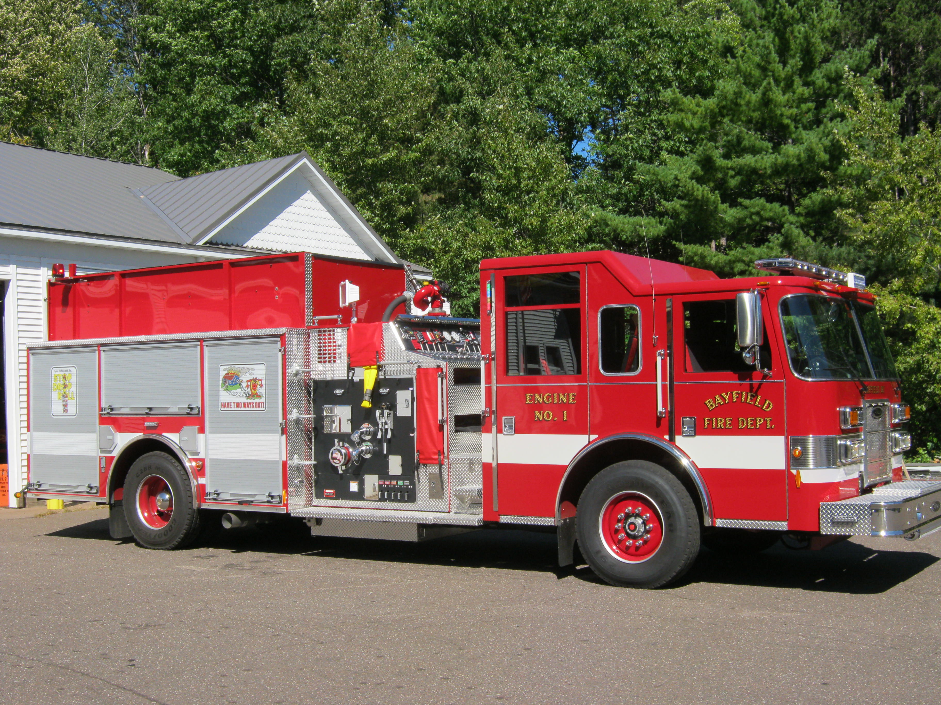 Passenger side image of Bayfield's fire department Engine #1 with red and white paint with gold lettering.